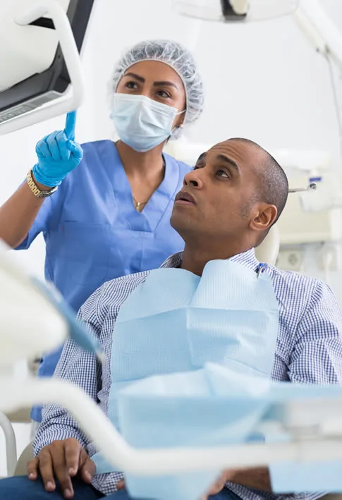 man in dental chair looking at monitor